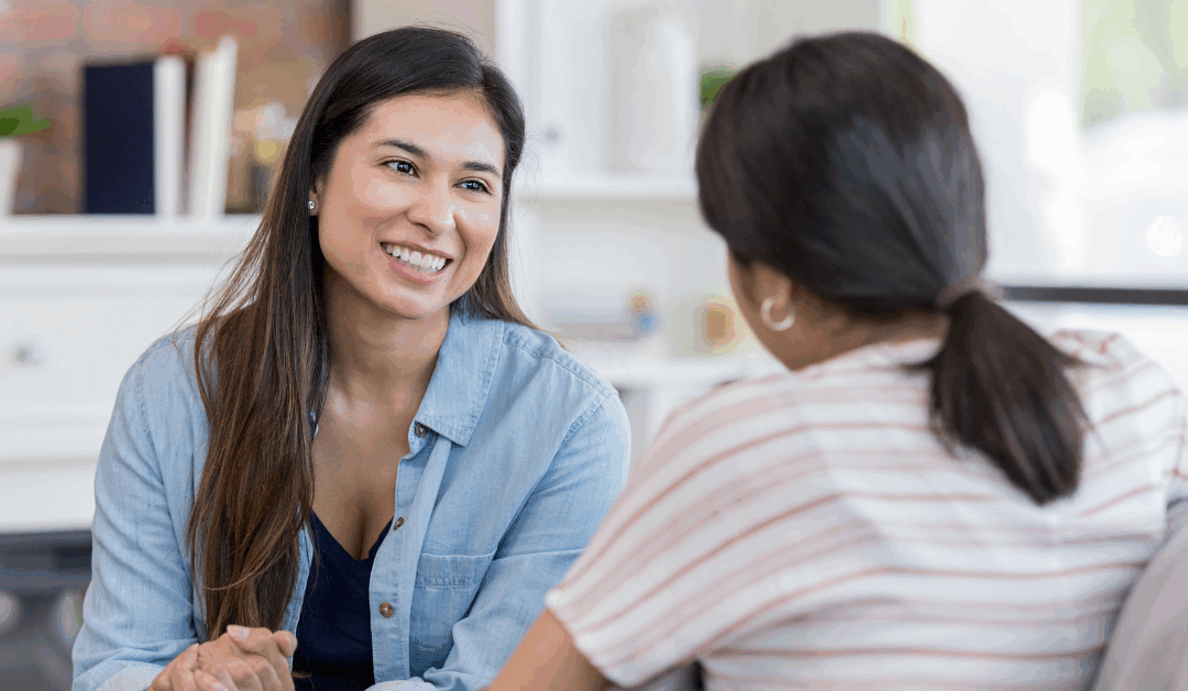 2 people facing each other chatting on the couch about healthy boundaries