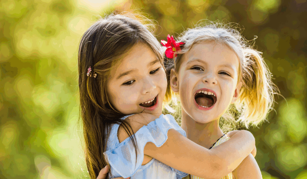 2 kids embracing laughing