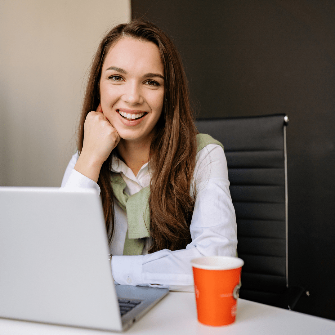 woman smiling while sitting in front of her laptop
